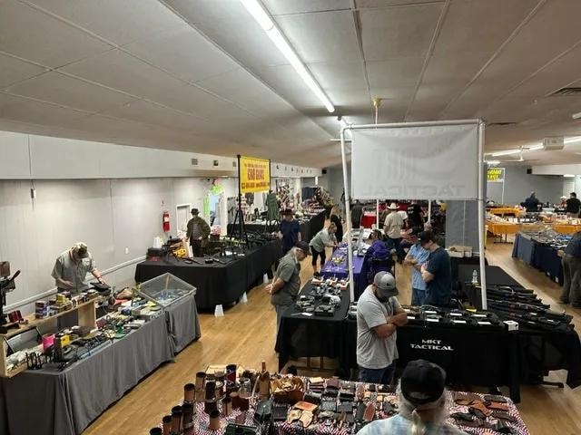 Indoor gun show with tactical gear and firearms